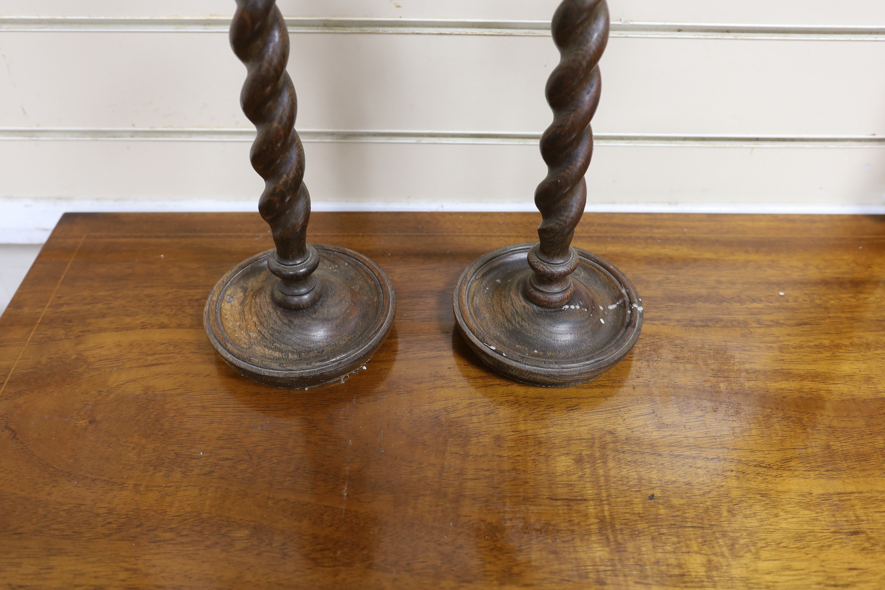 A pair of early 20th century spiral turned candlesticks with brass sconces, height 38cm